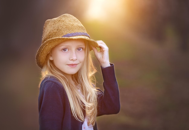 Foto porträt einer jungen frau mit hut, die im freien steht