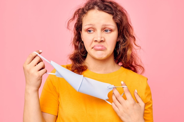 Porträt einer jungen Frau mit medizinischer Gesichtsmaske, Grimasse, Emotionen, Nahaufnahme, unbeschnittene Ansicht, unverändert