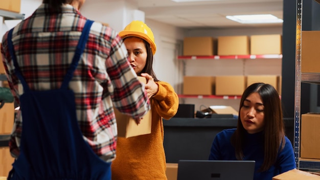 Foto porträt einer jungen frau mit mobiltelefon, während sie im büro steht