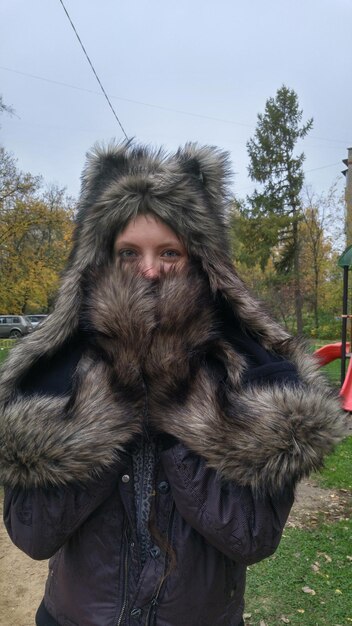 Porträt einer jungen Frau mit Pelzhut im Park