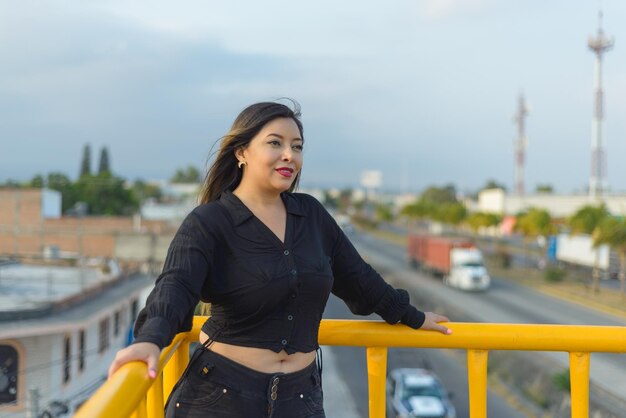 Porträt einer jungen Frau mit positiver Einstellung auf einer Fußgängerbrücke Sonnenuntergang mit blauem Himmel