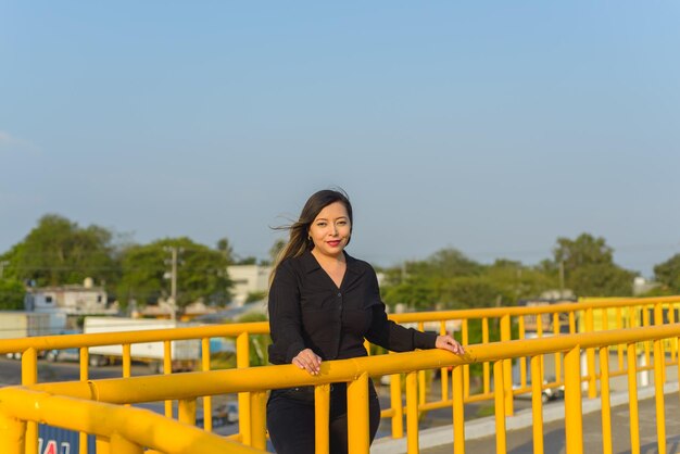 Porträt einer jungen Frau mit positiver Einstellung auf einer Fußgängerbrücke Sonnenuntergang mit blauem Himmel