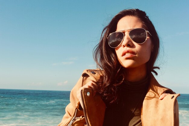 Foto porträt einer jungen frau mit sonnenbrille gegen den himmel