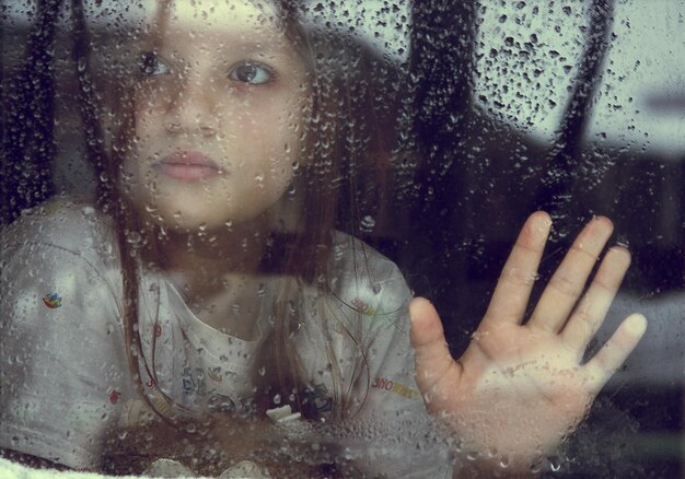 Porträt einer jungen Frau mit Spiegelung am Fenster