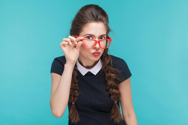 Porträt einer jungen Frau mit wevy Zöpfen und roter Brille