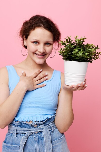 Porträt einer jungen Frau Topfblume posiert Pflanze rosa Hintergrund unverändert