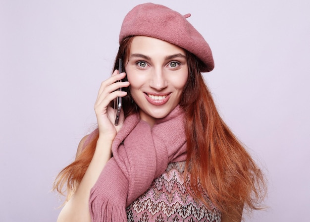 Porträt einer jungen Frau, welche die rosa Ausstattung spricht am Handy trägt