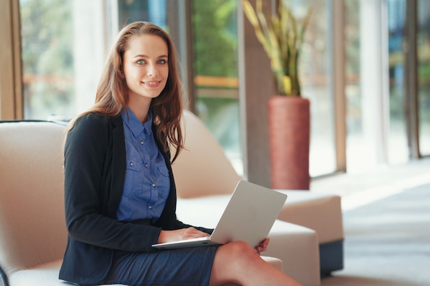 Porträt einer jungen Geschäftsfrau, die Laptop im Büro verwendet