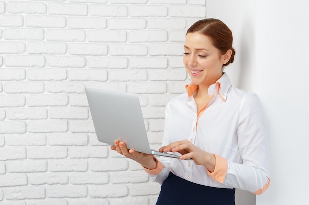 Porträt einer jungen Geschäftsfrau, die Laptop im Büro verwendet