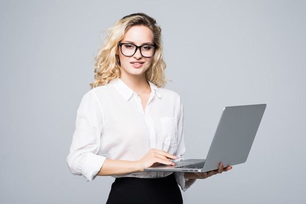 Porträt einer jungen glücklichen Geschäftsfrau mit einem Laptop über weißer Wand