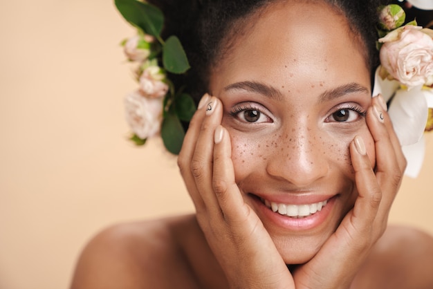 Foto porträt einer jungen halbnackten sommersprossigen afroamerikanerin mit blumen im haar