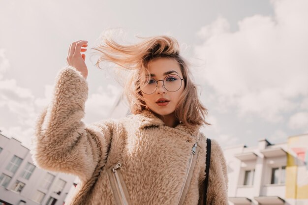 Porträt einer jungen Hipster-Frau, die eine Brille trägt und in die Kamera schaut