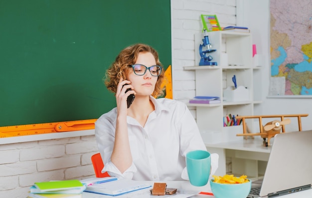 Porträt einer jungen kaukasischen Lehrerin oder Schülerin mit Handy fröhlicher Lehrerin im Unterricht t