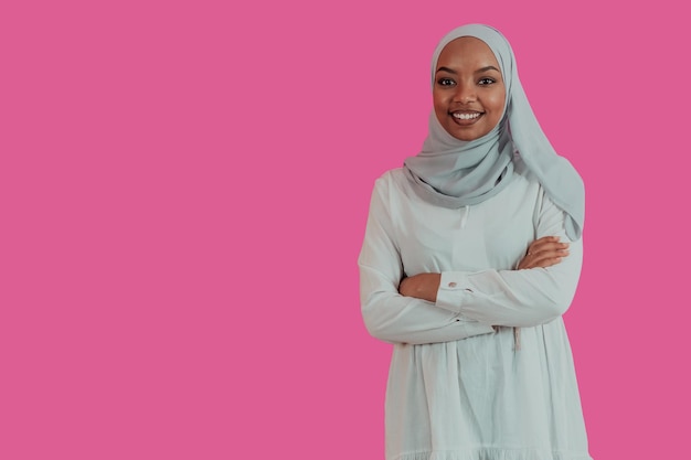 Porträt einer jungen modernen muslimischen afrikanischen Schönheit, die traditionelle islamische Kleidung auf rosafarbenem Kunststoffhintergrund trägt. Selektiver Fokus. Hochwertiges Foto