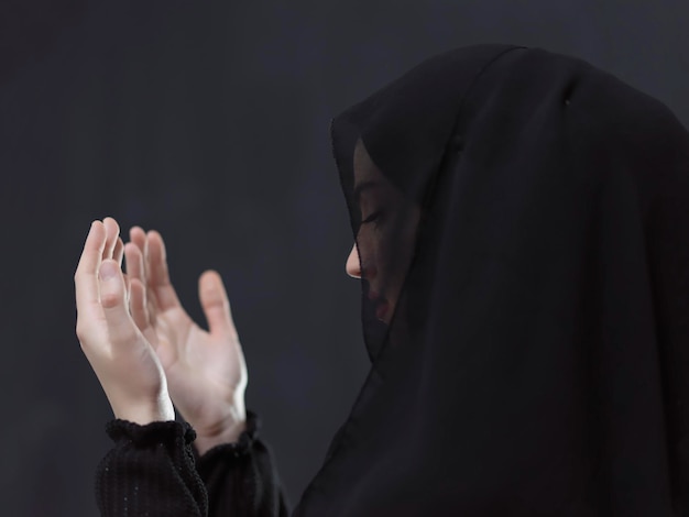 Porträt einer jungen muslimischen Frau, die Dua macht. Arabisches Mädchen, das Abaya trägt, hält die Hände in betender Geste. Darstellung der Anbetung Gottes und des Ramadan Kareem-Konzepts