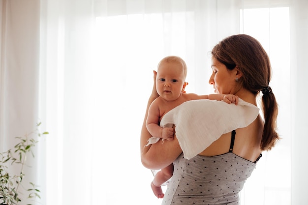 Porträt einer jungen Mutter, die ein neugeborenes Baby hält