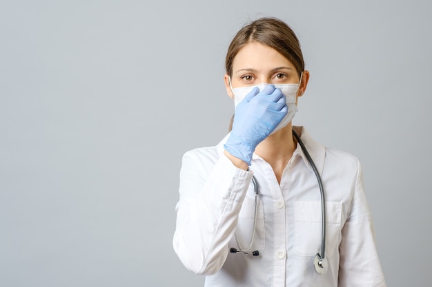 Porträt einer jungen Ärztin oder Krankenschwester, die sterile Maske setzt