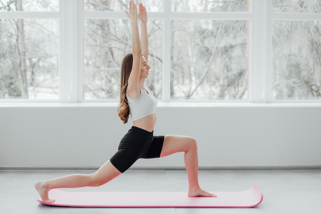 Porträt einer jungen schönen asiatischen Koreanerin, die sich zu Hause in Yoga-Position aufwärmt