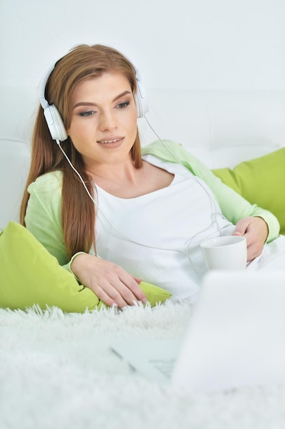 Porträt einer jungen schönen Frau, die sich im Bett entspannt