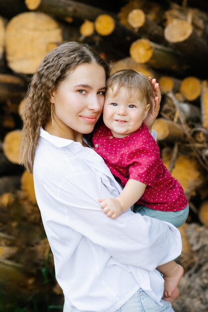 Foto porträt einer jungen schönen mutter und ihres kindes, das sie im freien in den armen hält