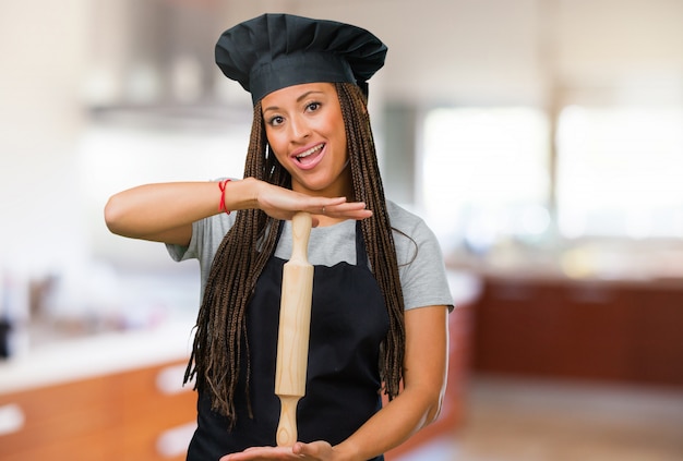 Porträt einer jungen schwarzen Bäckerfrau, die etwas mit den Händen hält
