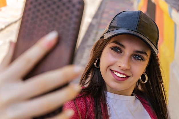 Foto porträt einer jungen tausendjährigen frau, die ein selfie mit ihrem smartphone auf der straße macht.