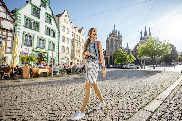 Porträt einer jungen Touristin, die mit Fotokamera in der Altstadt von Erfurt, Deutschland, reist