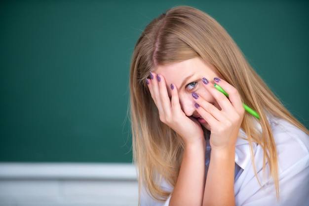 Porträt einer jungen weiblichen College-Schande peinlich berührtes Klassenzimmer im Unterricht mit Tafelhintergrund