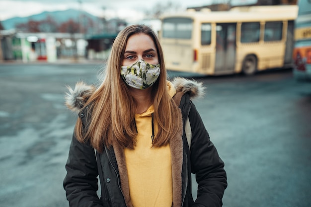 Porträt einer kaukasischen Frau, die eine stilvolle Maske mit Blumendruck trägt