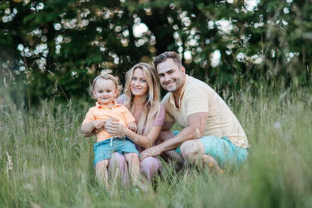 Porträt einer lächelnden Familie auf dem Feld im Park