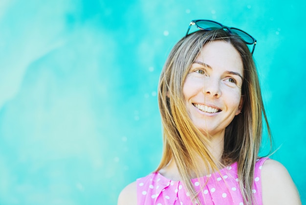 Foto porträt einer lächelnden frau auf einem hintergrund der blauen wand