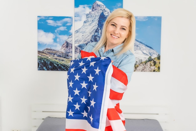 Porträt einer lächelnden Frau mit USA-Flagge auf weißem Hintergrund.