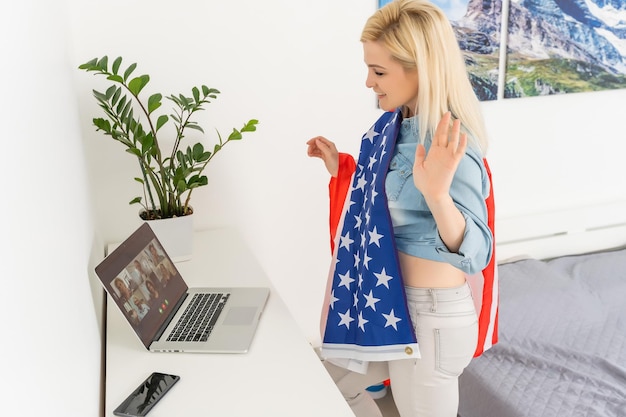 Porträt einer lächelnden Frau mit USA-Flagge auf weißem Hintergrund.