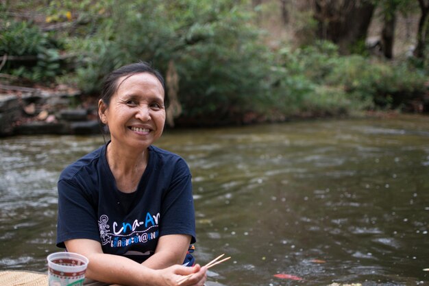 Foto porträt einer lächelnden frau vor dem fluss