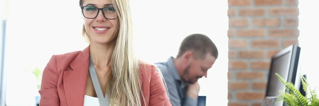 Porträt einer lächelnden Geschäftsfrau mit Brille im Büro