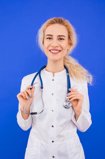 Porträt einer lächelnden jungen Ärztin auf blauem Hintergrund