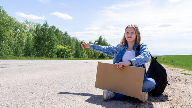 Foto porträt einer lächelnden jungen frau, die auf dem feld sitzt