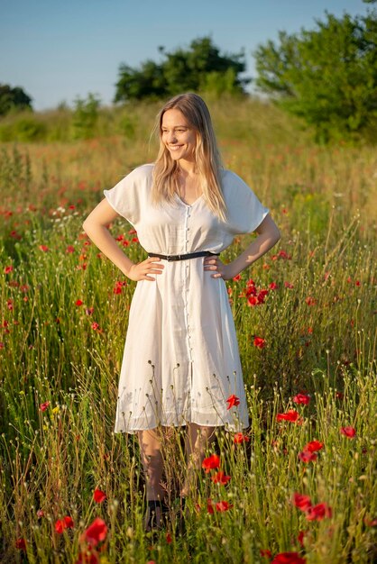 Foto porträt einer lächelnden jungen frau, die auf dem feld steht