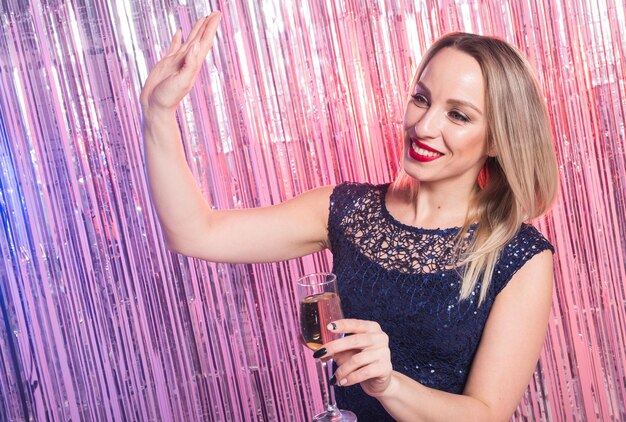 Foto porträt einer lächelnden jungen frau, die ein glas trinkt