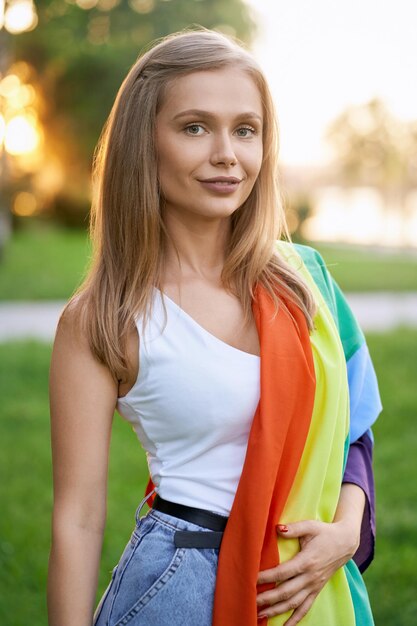 Foto porträt einer lächelnden jungen frau, die im freien steht