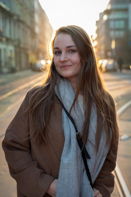 Foto porträt einer lächelnden jungen frau, die in der stadt steht