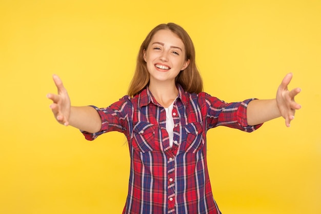 Porträt einer lächelnden jungen Frau, die vor einem gelben Hintergrund steht