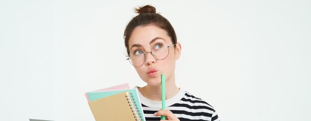 Foto porträt einer lächelnden jungen frau mit einem buch vor weißem hintergrund