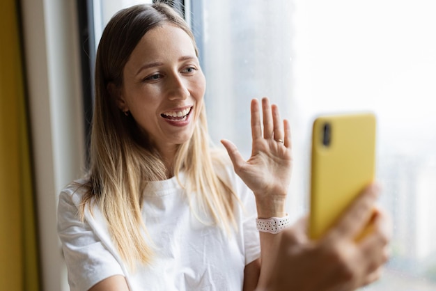 Foto porträt einer lächelnden jungen frau mit handy