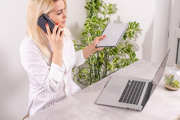 Foto porträt einer lächelnden jungen frau mit laptop und handy