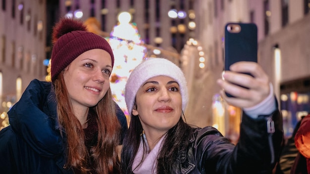 Foto porträt einer lächelnden jungen frau mit smartphone