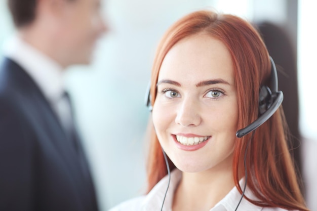 Porträt einer lächelnden kreativen Geschäftsfrau mit Ohrhörer im Büro