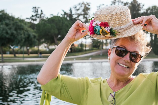 Porträt einer lächelnden pensionierten Frau mit Hut