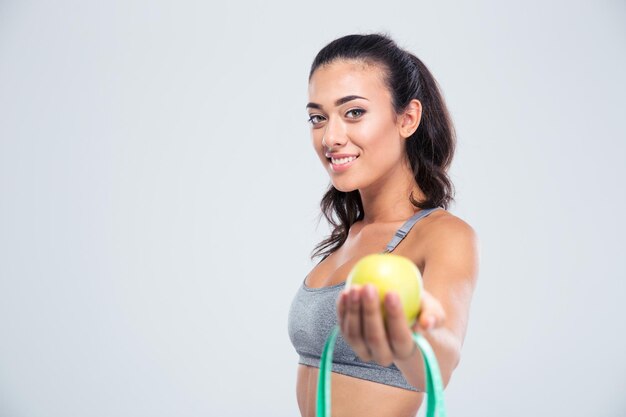 Porträt einer lächelnden Sportfrau, die Apfel und Messart lokalisiert auf einer weißen Wand hält