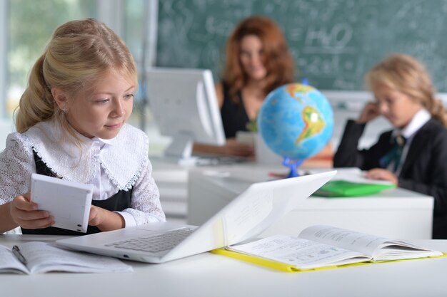 Porträt einer Lehrerin mit zwei Mädchen im Unterricht